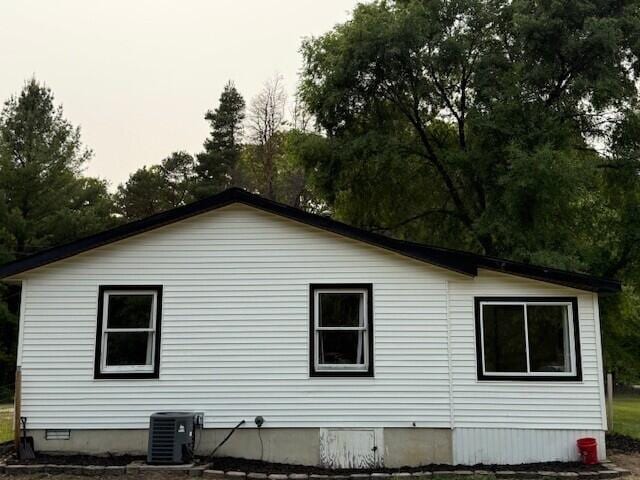 17912 130th Ave, Nunica, MI 49448 - view of side of property with central AC unit, view of wooded area, and crawl space