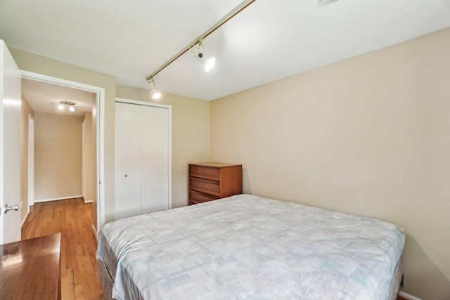 6883 Tamerlane Dr, West Bloomfield, MI 48322 - bedroom featuring wood finished floors, a closet, and track lighting