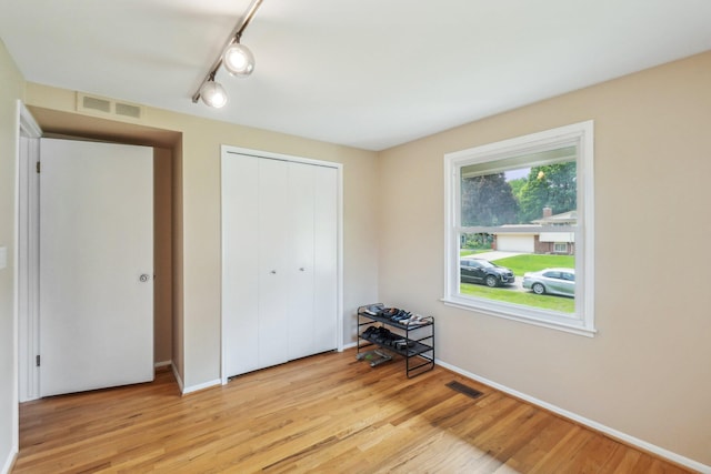 6883 Tamerlane Dr, West Bloomfield, MI 48322 - unfurnished bedroom with light wood-style flooring, a closet, and baseboards