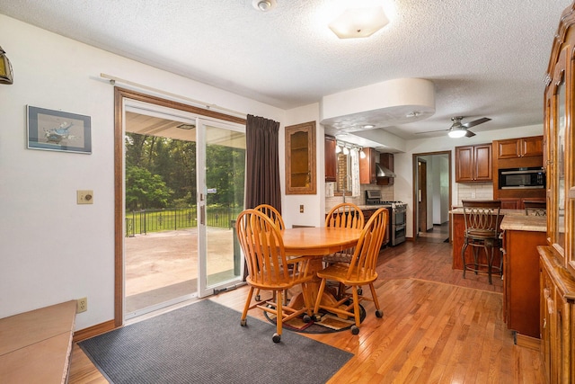 3765 Ryerson Rd, Twin Lake, MI 49457 - dining space with a textured ceiling, light wood-style flooring, ceiling fan, and baseboards