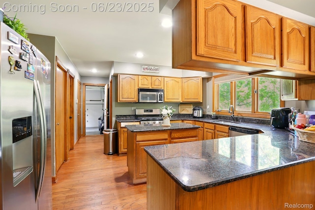 11970 Diamond Dr, Shelby Twp, MI 48315 - kitchen featuring appliances with stainless steel finishes, light wood-type flooring, a kitchen island, dark stone counters, and recessed lighting