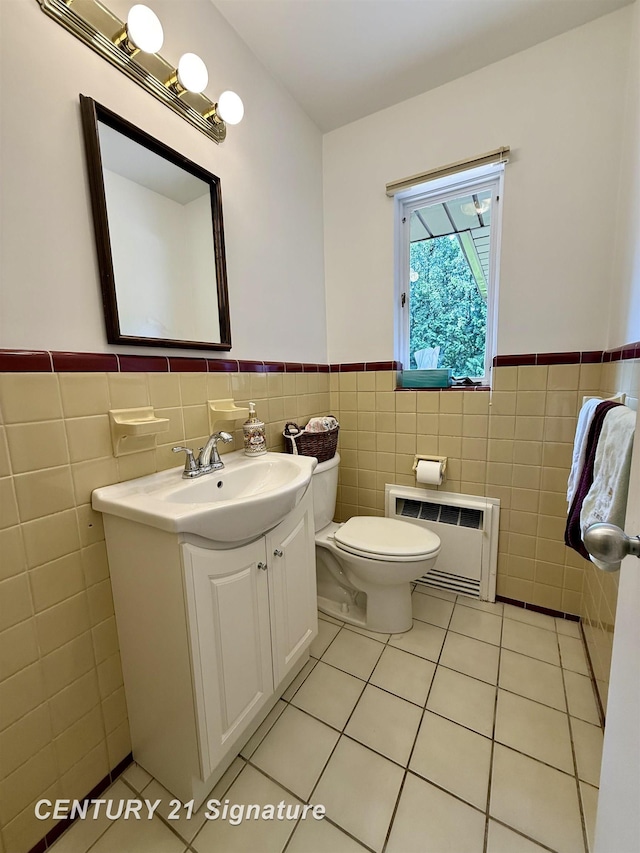 1486 Lathrup Ave, Saginaw, MI 48638 - half bathroom featuring radiator, tile walls, wainscoting, vanity, and tile patterned floors