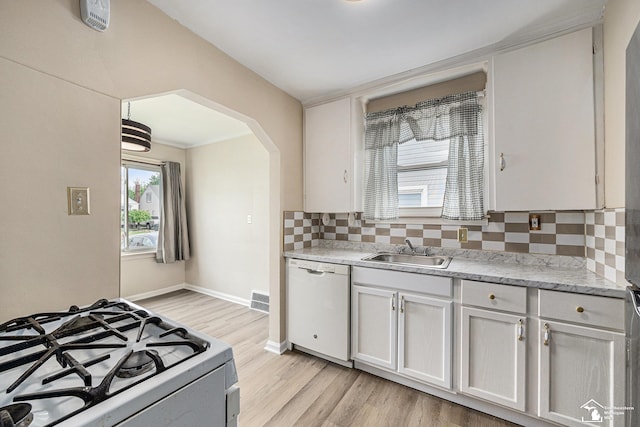 1989 Leblanc St, Lincoln Park, MI 48146 - kitchen featuring white appliances, a sink, arched walkways, decorative backsplash, and light wood finished floors