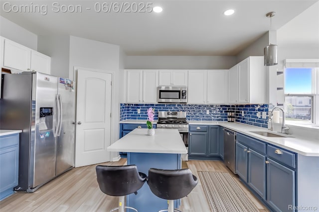 59625 Twin Pines Dr, New Hudson, MI 48165 - kitchen featuring appliances with stainless steel finishes, a sink, blue cabinets, light wood-style flooring, and recessed lighting
