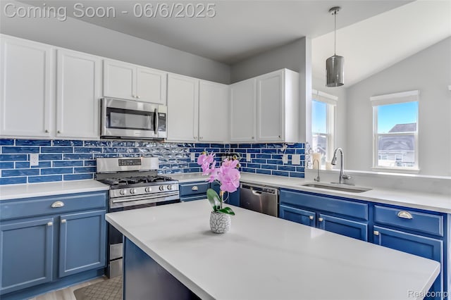 59625 Twin Pines Dr, New Hudson, MI 48165 - kitchen featuring appliances with stainless steel finishes, a sink, blue cabinetry, light countertops, and lofted ceiling