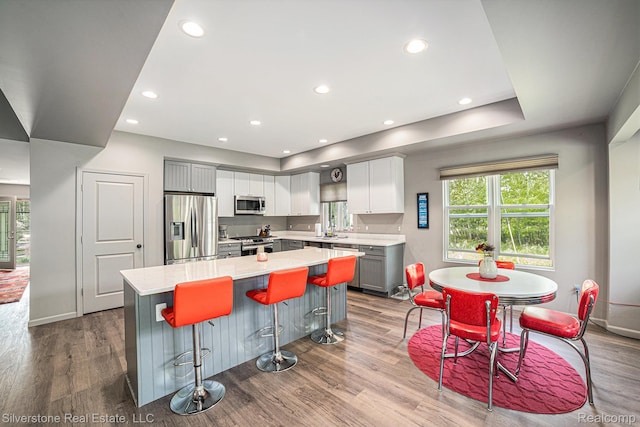 2816 W K Bar L Dr, Midland, MI 48640 - kitchen with stainless steel appliances, a center island, light countertops, gray cabinets, and wood finished floors