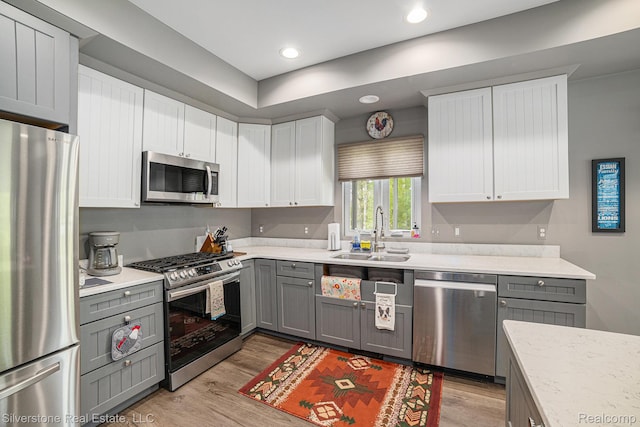 2816 W K Bar L Dr, Midland, MI 48640 - kitchen featuring stainless steel appliances, gray cabinetry, a sink, light wood-style floors, and recessed lighting