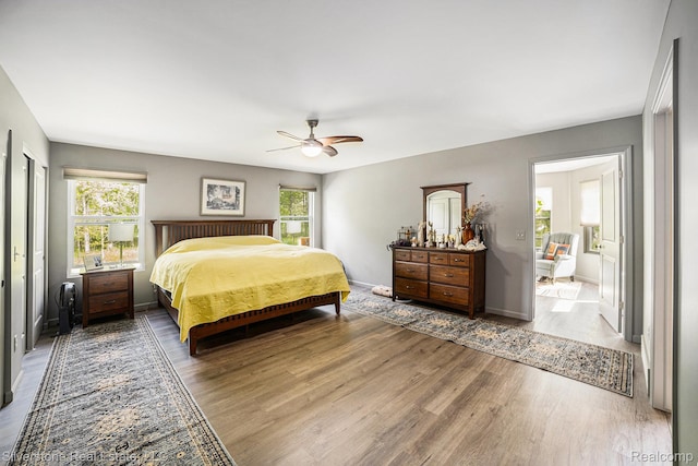 2816 W K Bar L Dr, Midland, MI 48640 - bedroom with wood finished floors, multiple windows, a ceiling fan, and baseboards