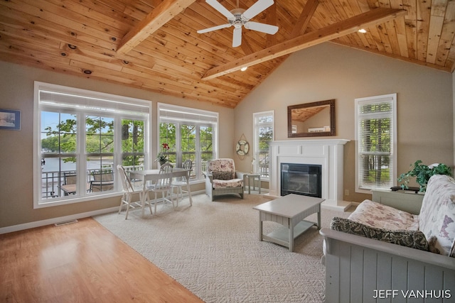 15021 S Star Lake Dr, Baldwin, MI 49304 - living room featuring wood ceiling with exposed beams, a glass covered fireplace, ceiling fan, wood finished floors, and baseboards