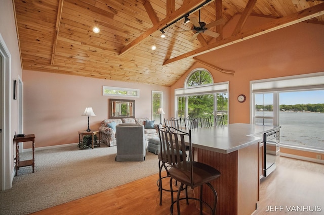 15021 S Star Lake Dr, Baldwin, MI 49304 - kitchen featuring wooden ceiling with exposed beams, open floor plan, light wood-style flooring, baseboards, and ceiling fan
