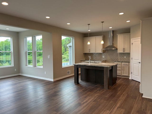 2924 Sheridan Cir Unit 57, Jackson, MI 49201 - kitchen with wall chimney range hood, dark wood-style flooring, decorative backsplash, recessed lighting, and a kitchen island with sink