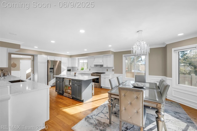 636 Morley Ct, Dearborn, MI 48124 - dining area with beverage cooler, healthy amount of natural light, light wood-style flooring, ornamental molding, and a chandelier