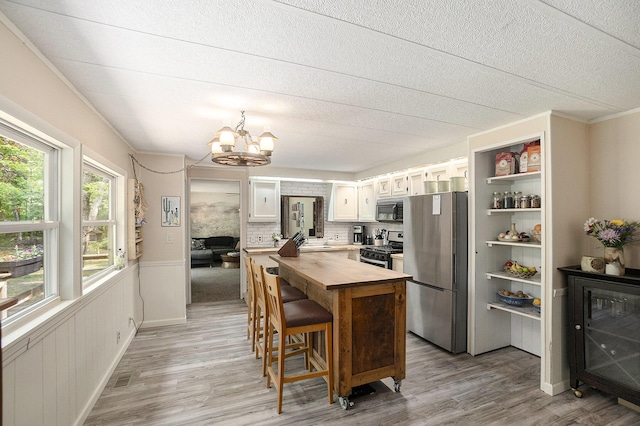 3274 E Rivers Edge, Newaygo, MI 49337 - kitchen featuring stainless steel appliances, butcher block countertops, a chandelier, a sink, and light wood-style floors