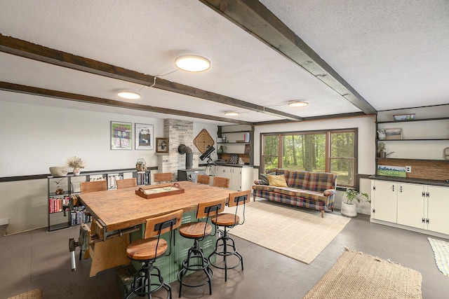 3274 E Rivers Edge, Newaygo, MI 49337 - dining room featuring beam ceiling, a wood stove, a textured ceiling, and finished concrete flooring