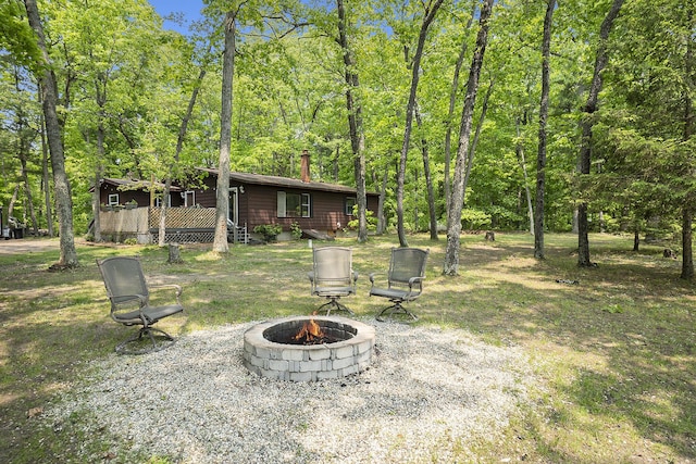 3274 E Rivers Edge, Newaygo, MI 49337 - view of yard featuring a fire pit, a deck, and a forest view