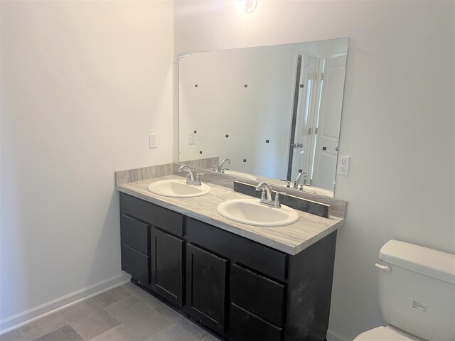 1050 Rebecca St Unit 18, Marshall, MI 49068 - full bathroom featuring double vanity, toilet, and baseboards