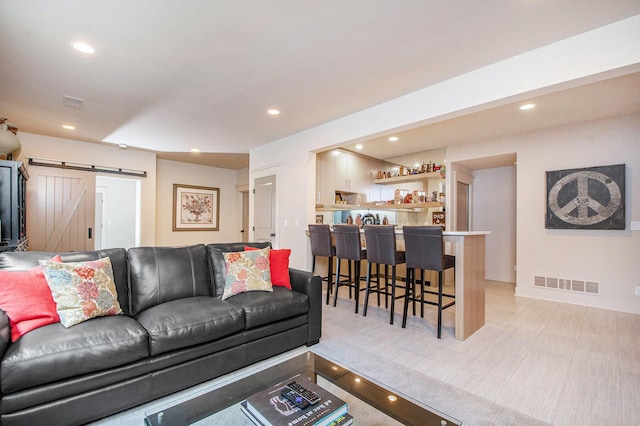 2234 Lake Dr SE, East Grand Rapids, MI 49506 - living room featuring a barn door, bar area, and recessed lighting