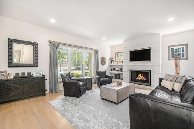2234 Lake Dr SE, East Grand Rapids, MI 49506 - living area featuring light wood finished floors, a lit fireplace, and recessed lighting