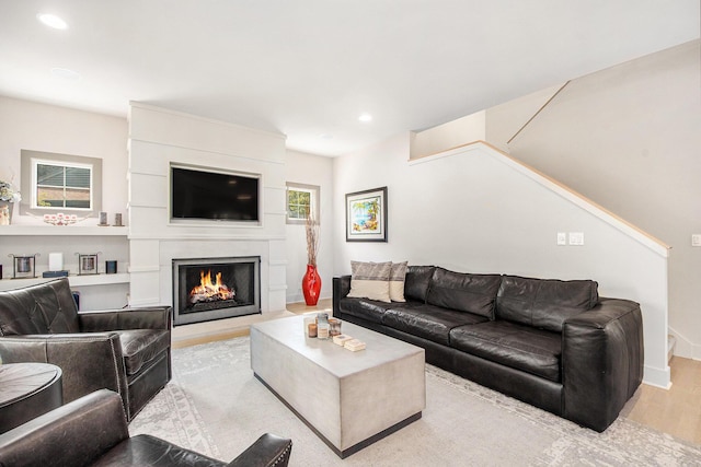 2234 Lake Dr SE, East Grand Rapids, MI 49506 - living room with light wood-type flooring, stairs, recessed lighting, a large fireplace, and baseboards