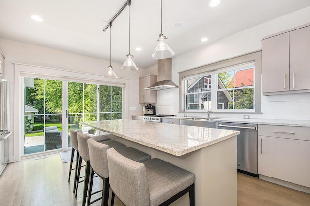 2234 Lake Dr SE, East Grand Rapids, MI 49506 - kitchen with stainless steel dishwasher, extractor fan, light wood-style floors, a kitchen island, and recessed lighting