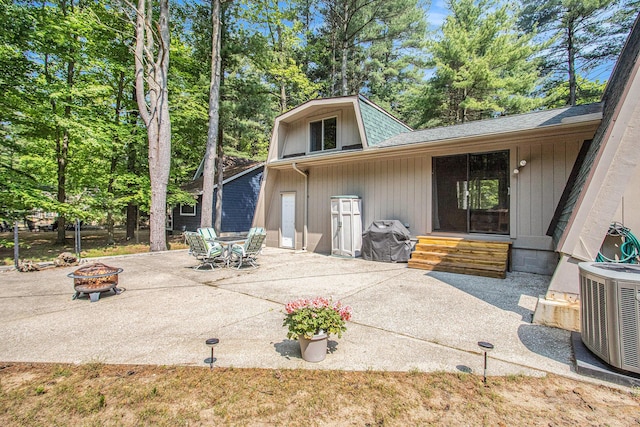 77125 Pinewood Ln, South Haven, MI 49090 - rear view of house featuring a fire pit, a patio area, roof with shingles, central AC unit, and entry steps