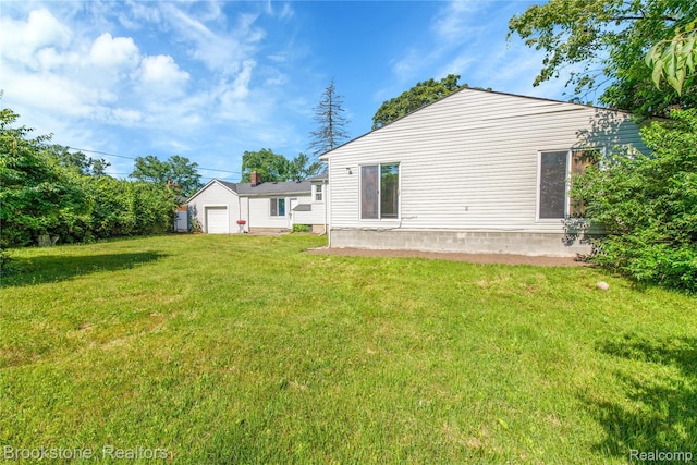 20930 Stahelin Rd, Southfield, MI 48075 - rear view of house featuring a lawn and a detached garage
