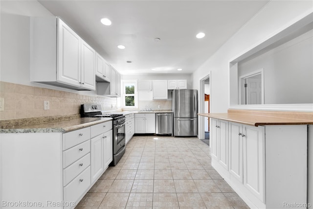 20930 Stahelin Rd, Southfield, MI 48075 - kitchen featuring appliances with stainless steel finishes, backsplash, white cabinetry, light countertops, and recessed lighting