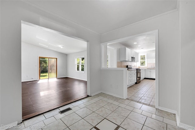 20930 Stahelin Rd, Southfield, MI 48075 - kitchen with stainless steel range, light tile patterned floors, white cabinets, light countertops, and open floor plan