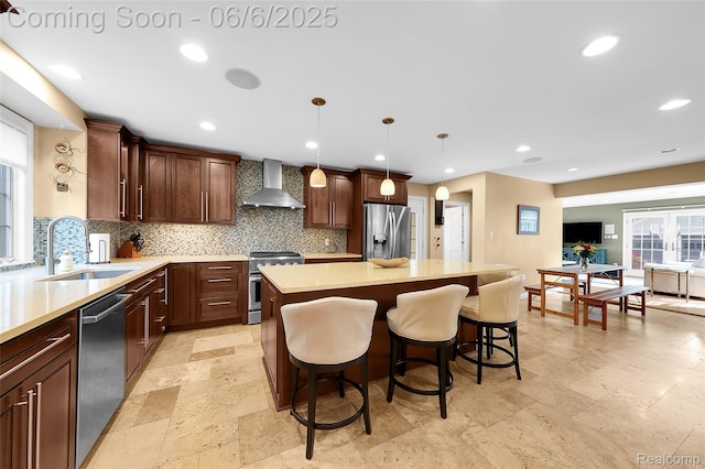 828 Westchester Rd, Grosse Pointe Park, MI 48230 - kitchen with appliances with stainless steel finishes, wall chimney exhaust hood, a sink, tasteful backsplash, and recessed lighting