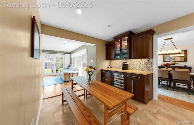 828 Westchester Rd, Grosse Pointe Park, MI 48230 - kitchen with beverage cooler, stone tile floors, backsplash, dark brown cabinetry, and glass insert cabinets