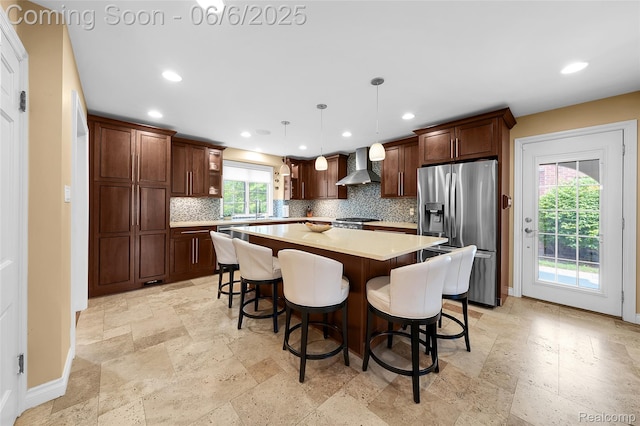 828 Westchester Rd, Grosse Pointe Park, MI 48230 - kitchen with stainless steel refrigerator with ice dispenser, wall chimney exhaust hood, stone tile floors, decorative backsplash, and a center island
