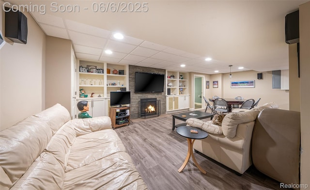 828 Westchester Rd, Grosse Pointe Park, MI 48230 - living room with wood finished floors, a stone fireplace, built in features, recessed lighting, and a drop ceiling