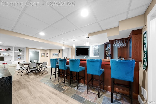 828 Westchester Rd, Grosse Pointe Park, MI 48230 - indoor wet bar with a drop ceiling, built in shelves, wood finished floors, pendant lighting, and recessed lighting