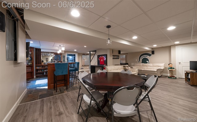 828 Westchester Rd, Grosse Pointe Park, MI 48230 - dining area featuring baseboards, a bar, a paneled ceiling, wood finished floors, and recessed lighting