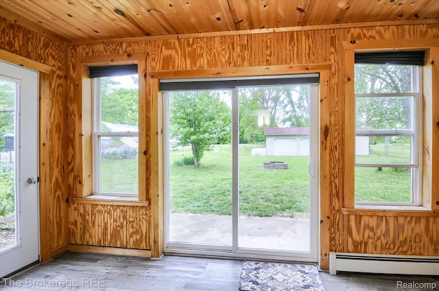 11305 Cook Rd, Gaines, MI 48436 - doorway with baseboard heating, wood walls, wood ceiling, plenty of natural light, and light wood-type flooring
