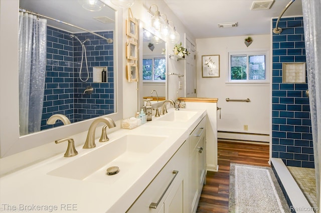 11305 Cook Rd, Gaines, MI 48436 - bathroom with a baseboard heating unit, wood finished floors, healthy amount of natural light, and a tile shower