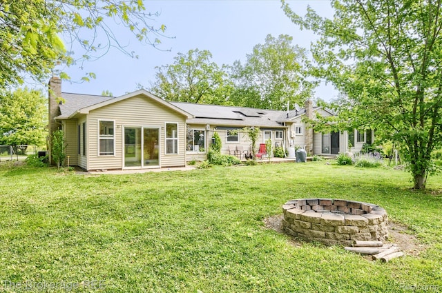 11305 Cook Rd, Gaines, MI 48436 - back of house featuring a chimney, a fire pit, and a yard