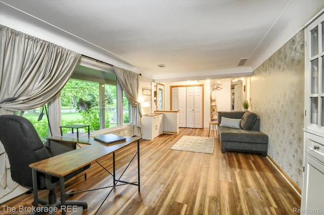 11305 Cook Rd, Gaines, MI 48436 - living area featuring wood finished floors, wallpapered walls, and a desk