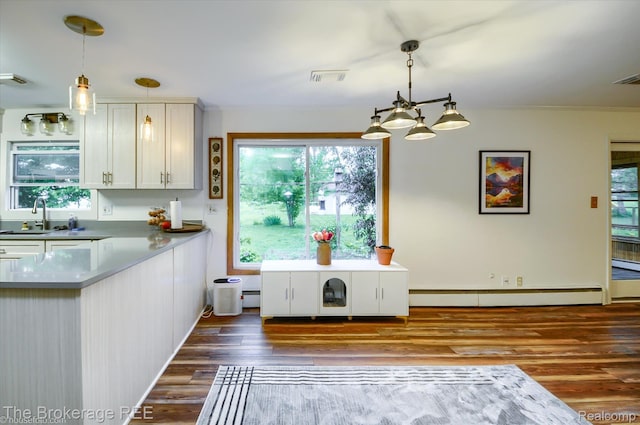 11305 Cook Rd, Gaines, MI 48436 - kitchen with wood finished floors, a baseboard radiator, hanging light fixtures, white cabinets, and a sink