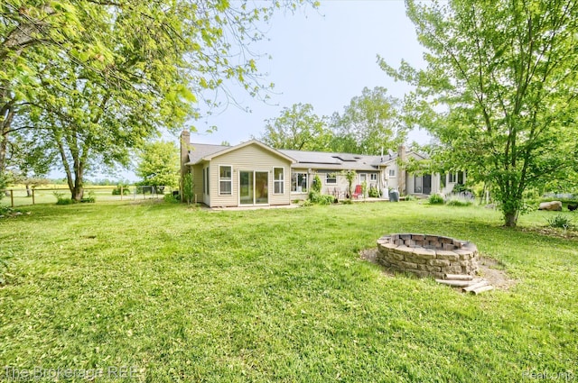 11305 Cook Rd, Gaines, MI 48436 - back of property featuring an outdoor fire pit, a chimney, and a yard