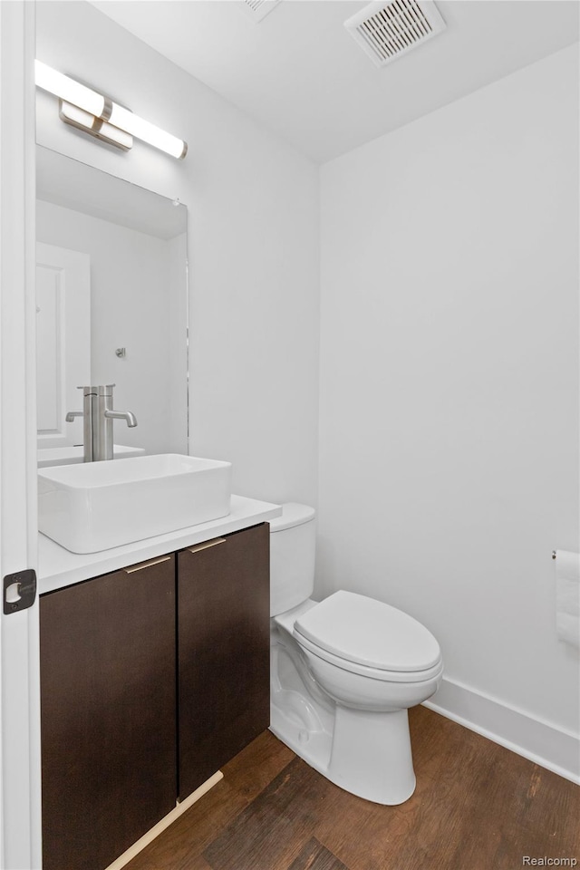 3420 Cochrane St Unit 2, Detroit, MI 48208 - half bathroom featuring wood finished floors, vanity, toilet, and baseboards