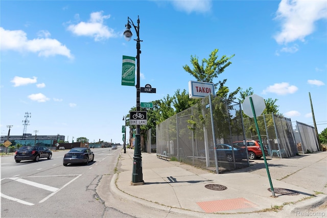3420 Cochrane St Unit 2, Detroit, MI 48208 - view of asphalt road featuring sidewalks, traffic signs, curbs, and street lighting