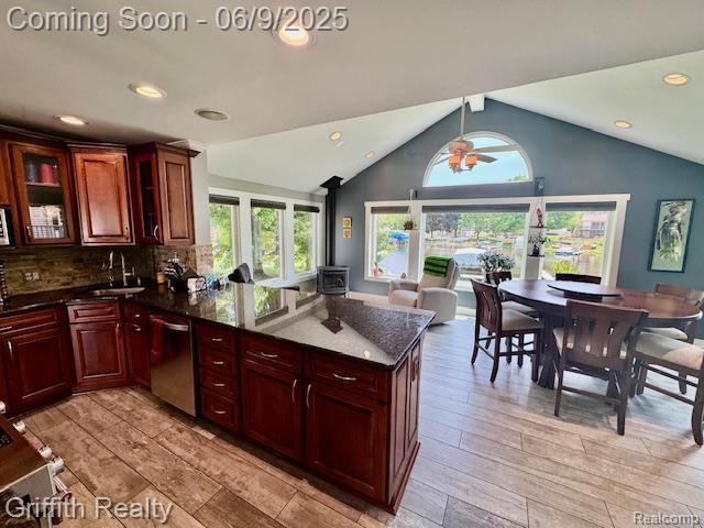 1158 Camelot Dr, Pinckney, MI 48169 - kitchen with dishwasher, lofted ceiling, a peninsula, recessed lighting, and glass insert cabinets