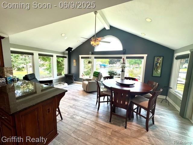 1158 Camelot Dr, Pinckney, MI 48169 - dining area featuring a wood stove, light wood-style flooring, and baseboards