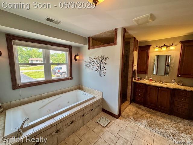 1158 Camelot Dr, Pinckney, MI 48169 - full bathroom featuring vanity, a tub with jets, tile patterned floors, and a shower