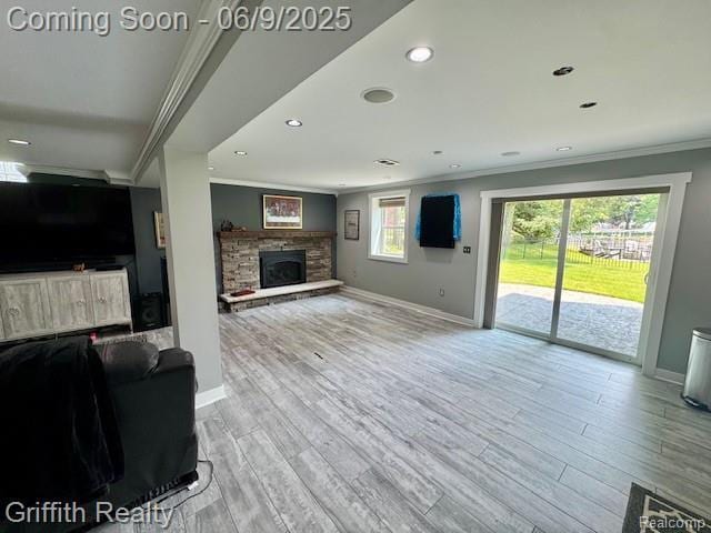 1158 Camelot Dr, Pinckney, MI 48169 - unfurnished living room with ornamental molding, baseboards, wood finished floors, a stone fireplace, and recessed lighting