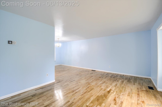 732 E Grand Blanc Rd, Grand Blanc, MI 48439 - additional living space with a chandelier, wood finished floors, and baseboards