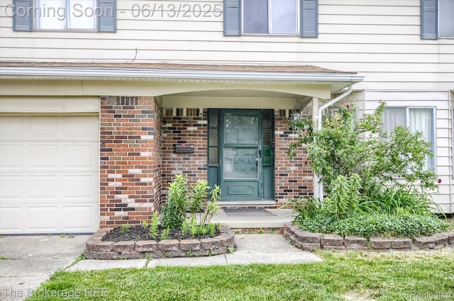 732 E Grand Blanc Rd, Grand Blanc, MI 48439 - view of exterior entry with brick siding and an attached garage
