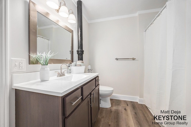 109 Leonard St NE, Grand Rapids, MI 49503 - bathroom with ornamental molding, vanity, toilet, wood finished floors, and baseboards