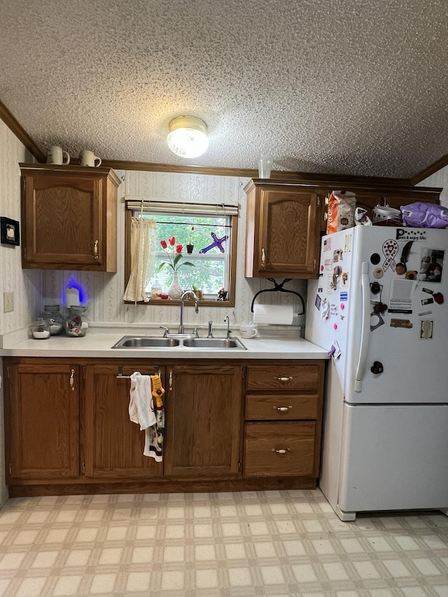 4153 Whisperwood Way S, Muskegon, MI 49442 - kitchen featuring freestanding refrigerator, a sink, ornamental molding, light countertops, and light floors